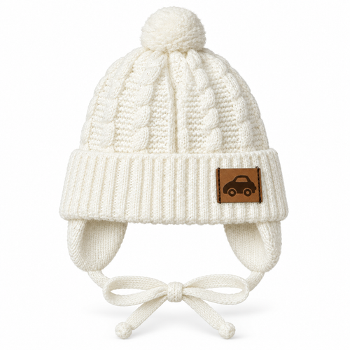 Cream cable-knit baby boy cap with pompom, car patch, ear flaps and tie strings – front view