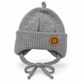Grey knitted baby cap with lion patch, chunky ribbed cuff, ear flaps and tie strings – front view