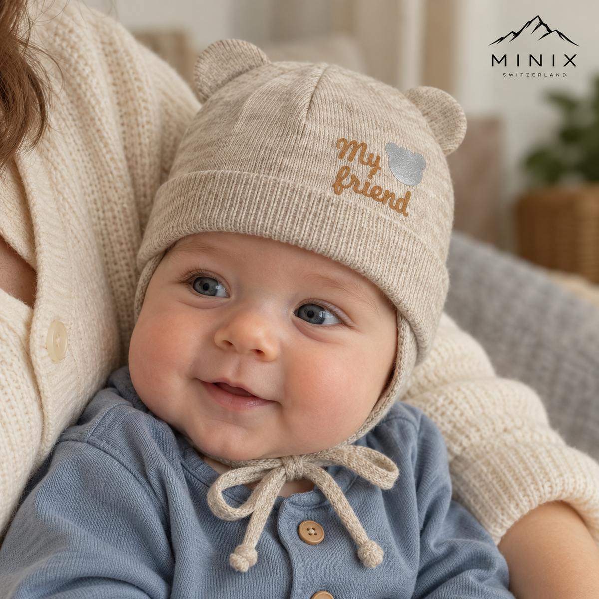 Baby in a parent's arms wearing the beige MINIX knitted bear ears cap