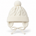 Cream basketweave knit baby cap with pompom, ribbed cuff, ear flaps and tie strings – front view