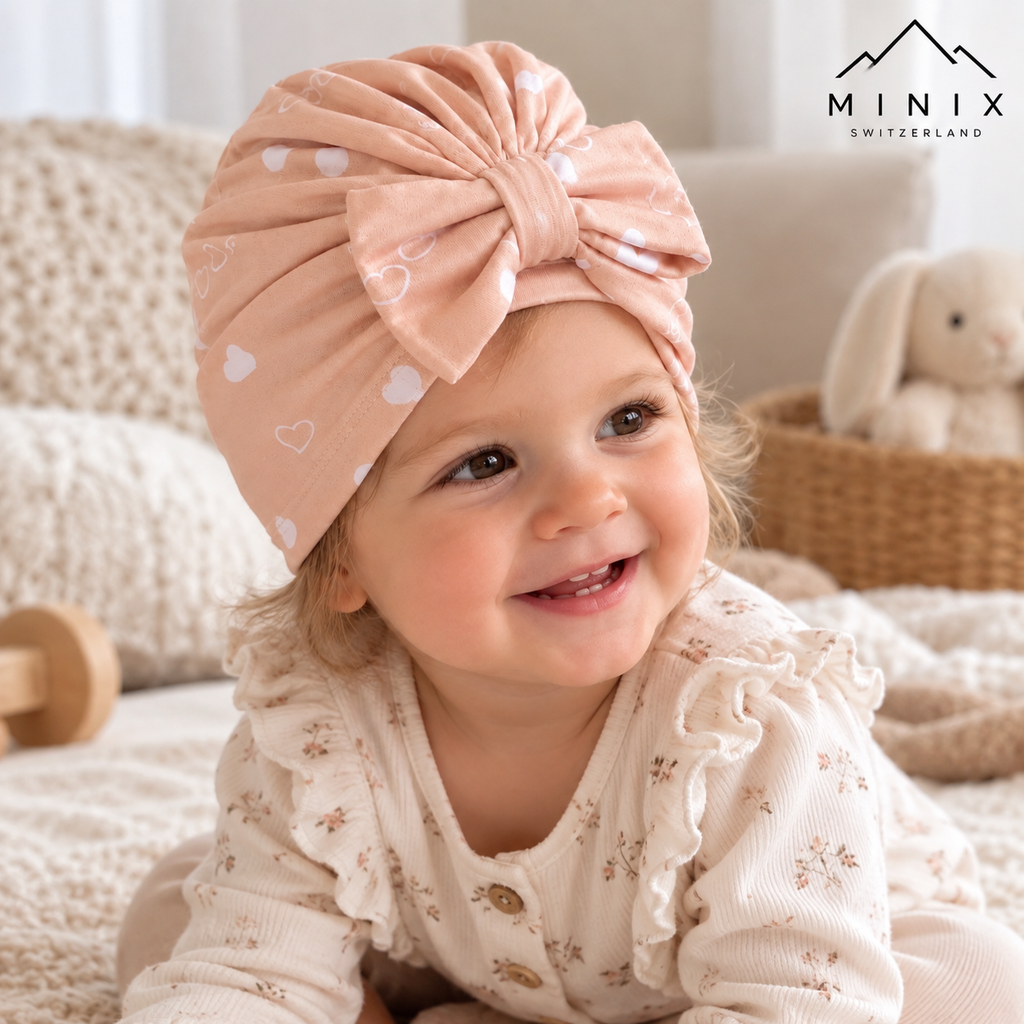 Baby wearing the pink heart-print MINIX cotton turban cap with bow