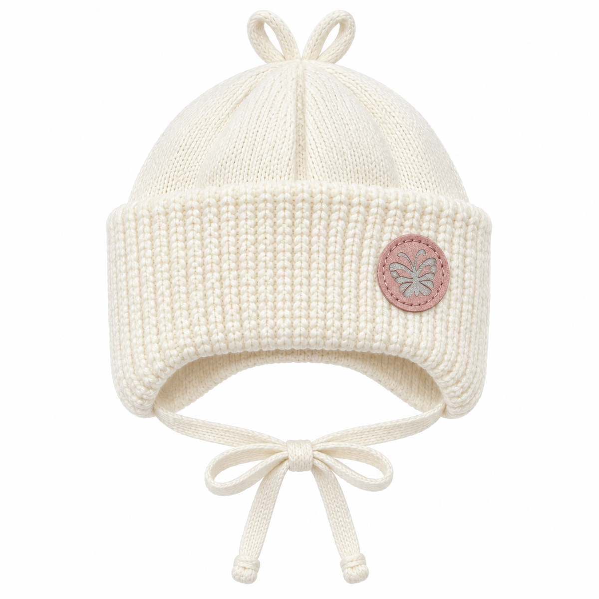 Cream knitted baby girl cap with pink butterfly patch, chunky ribbed cuff, ear flaps and tie strings – front view