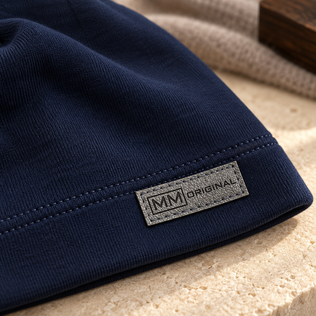 Close-up of the grey MM Original label on a navy kids cotton beanie