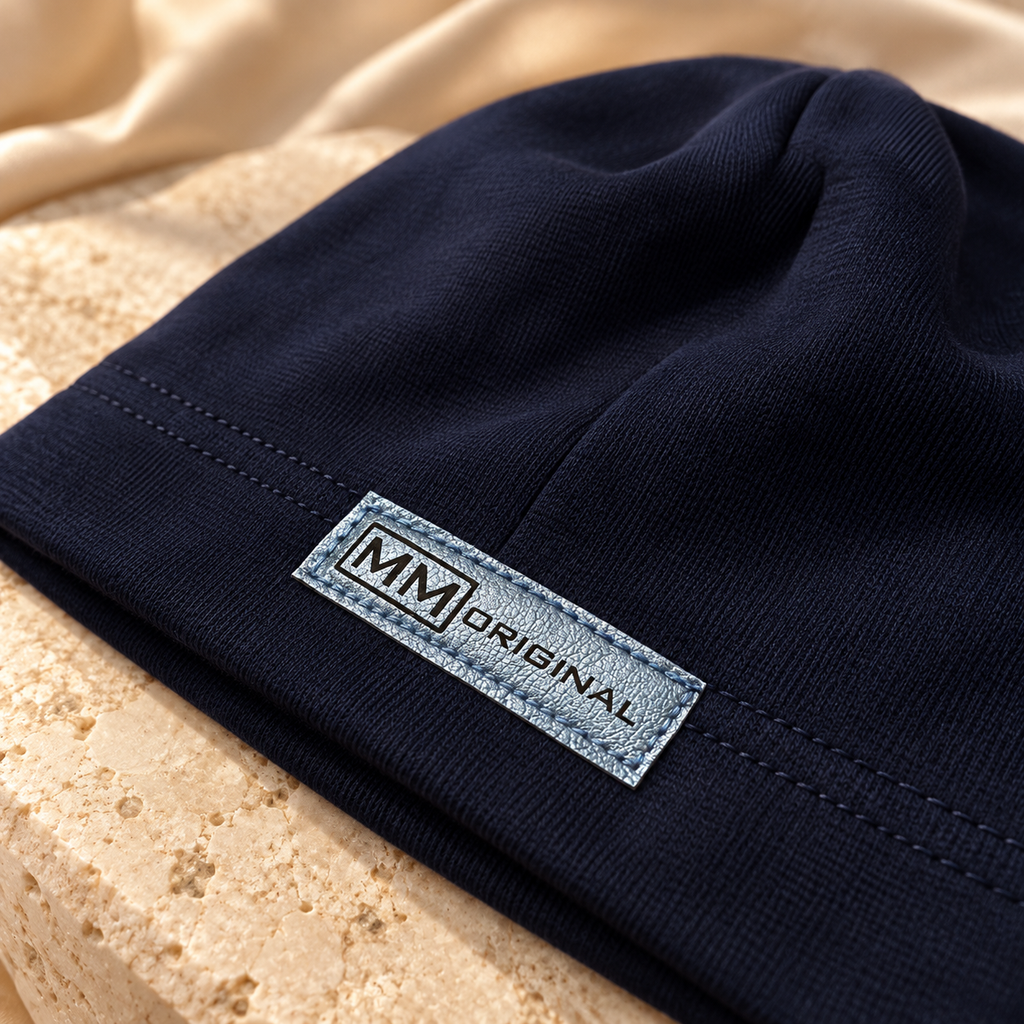 Close-up of the metallic MM Original label on a navy kids cotton beanie