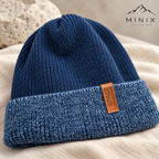 Close-up of the Space Adventure tag and blue mélange cuff on the navy knitted beanie